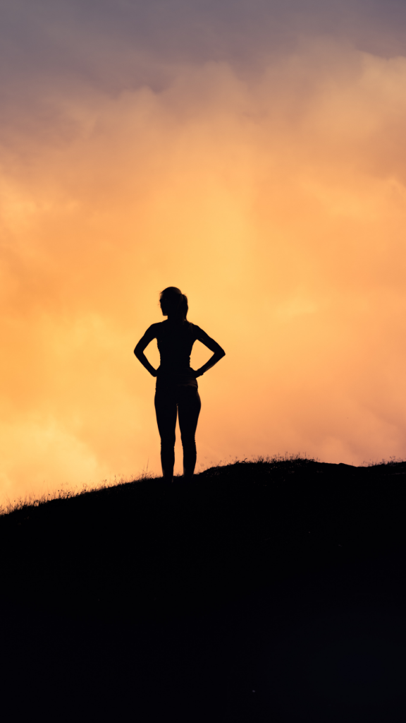 thriving woman standing on hill